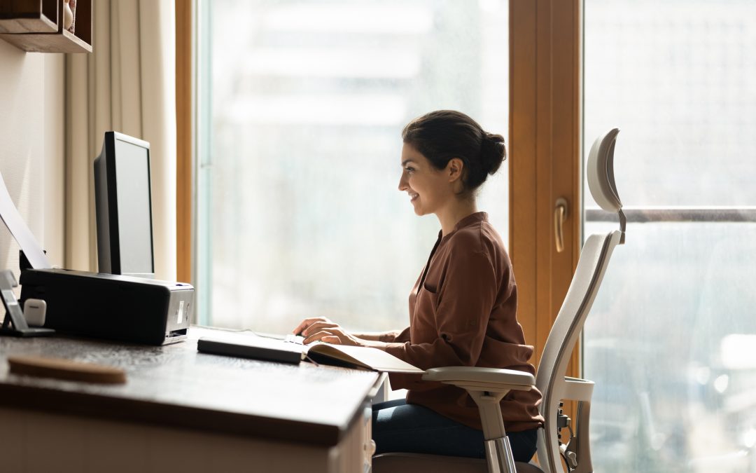 woman sitting in ergonomic office chair, working at computer